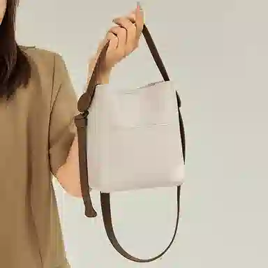纳兰杜 大容量夏季百搭实用通勤纯色手提包时尚潮流女包 牛皮 水桶包斜挎包单肩包 小号 女款 米白色 / 奶茶色 /盐卡色